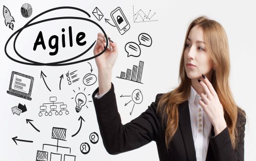 A woman in a suit points to the word Agile to symbolize proactive actions