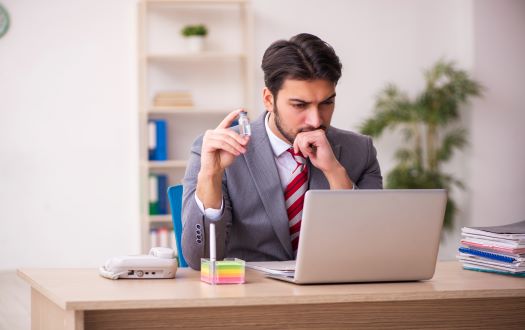 Lawyer in a suit, sitting in front of a laptop pondering vaccine mandates